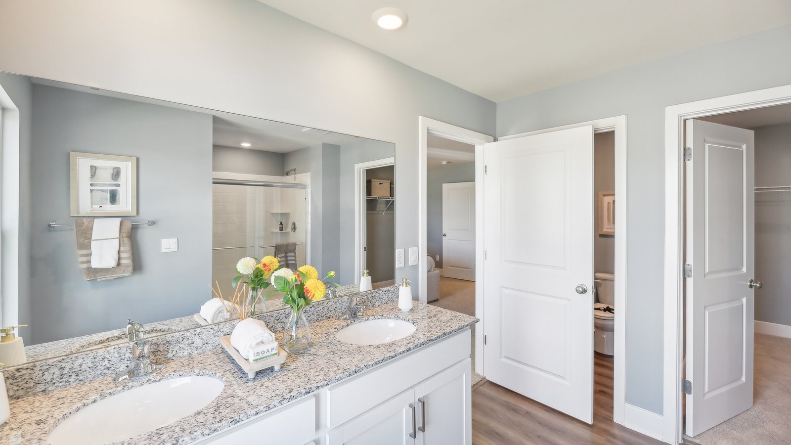 primary bathroom with dual sink vanity and walk in shower