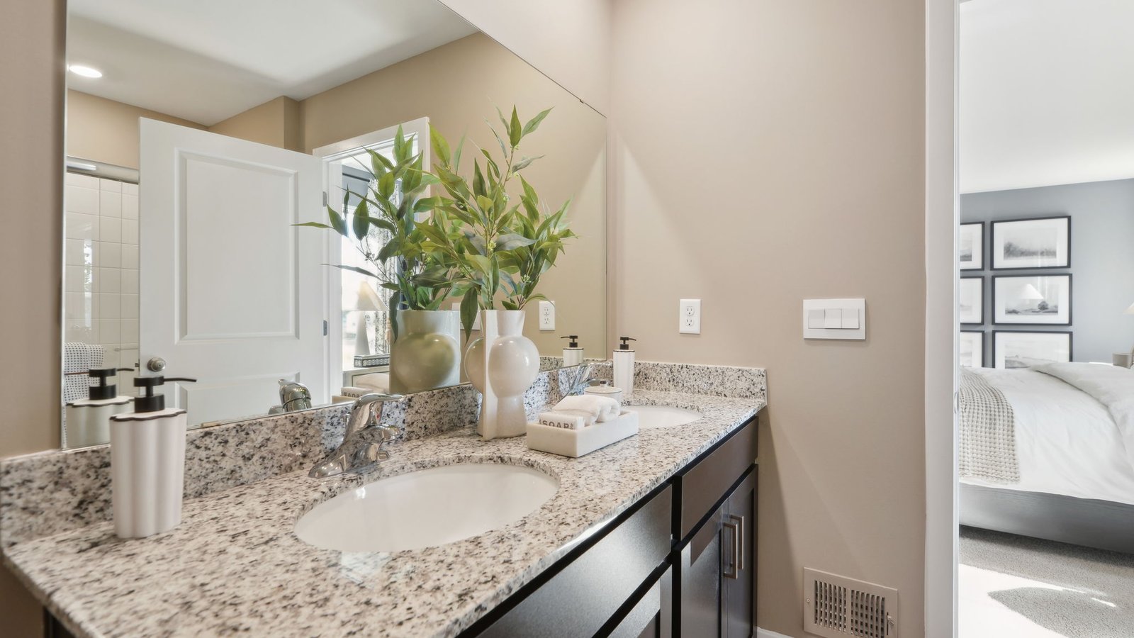 Luxurious primary bathroom in a new construction home featuring dual vanities, contemporary fixtures, and a private en suite design.