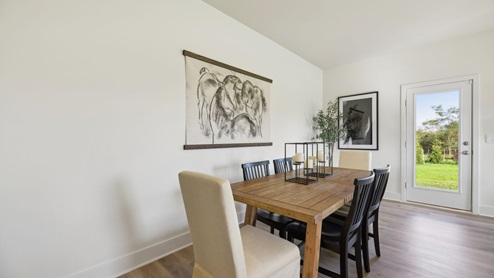 On the other side, the dining table overlooks the back door leading into the backyard