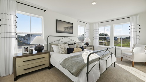 Primary bedroom has lots of natural light that come though its 4 windows