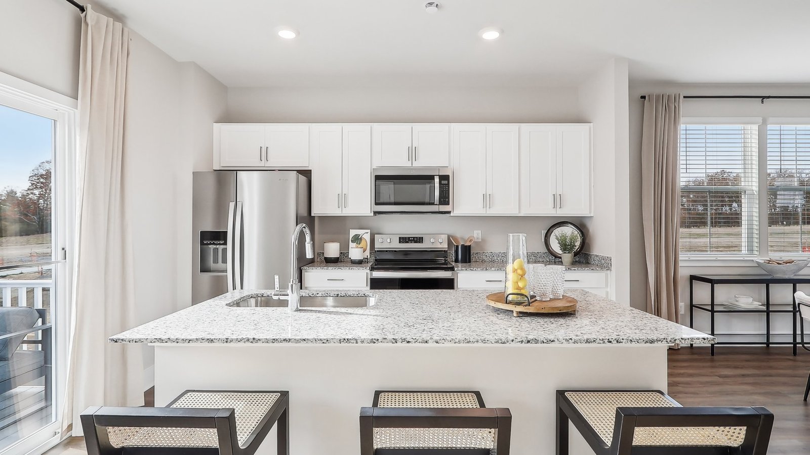 Modern kitchen in Winchester VA townhome with gray cabinets, quartz countertops, stainless steel Whirlpool appliances, and open-concept layout.