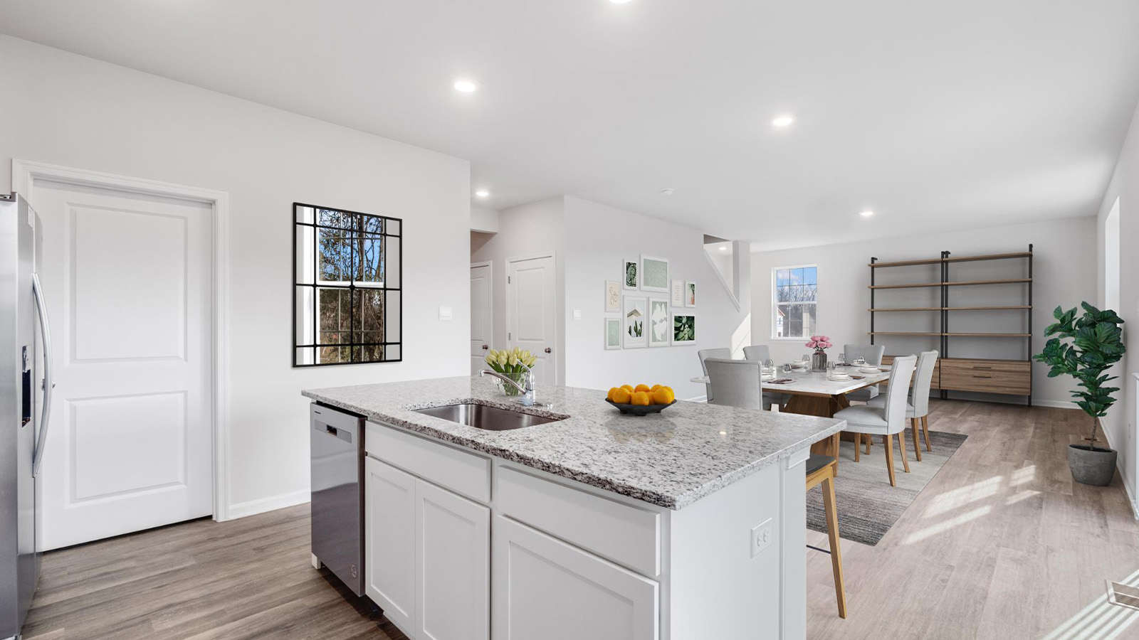 Kitchen with white cabinets that flows into a great room