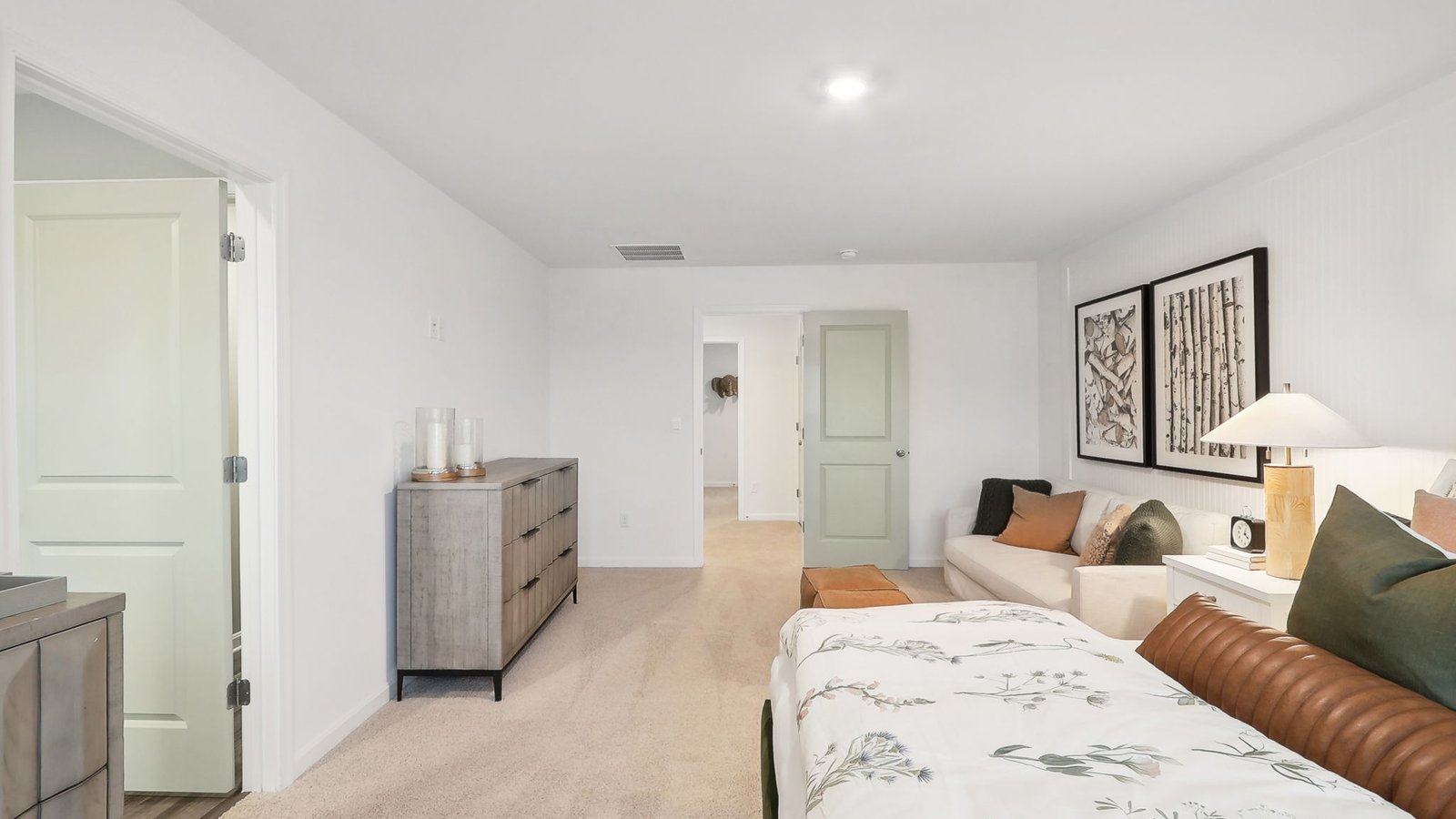 modern spacious primary bedroom with seating area
