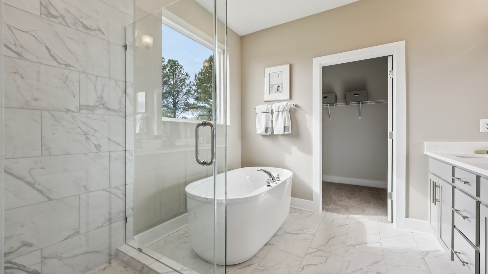 primary en suite bathrom with dual sink vanity and walk in shower and tub