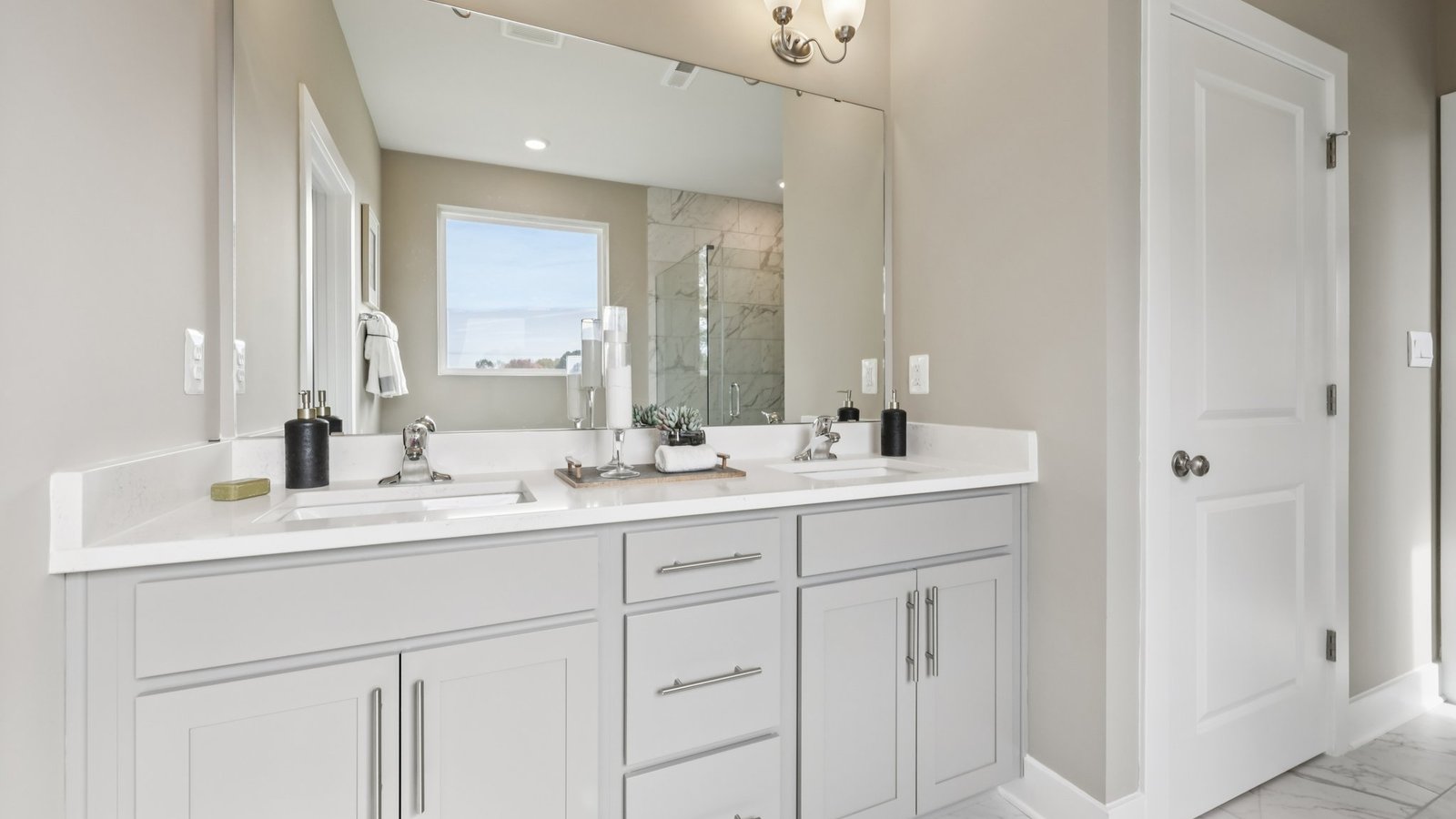 primary en suite bathrom with dual sink vanity and walk in shower and tub