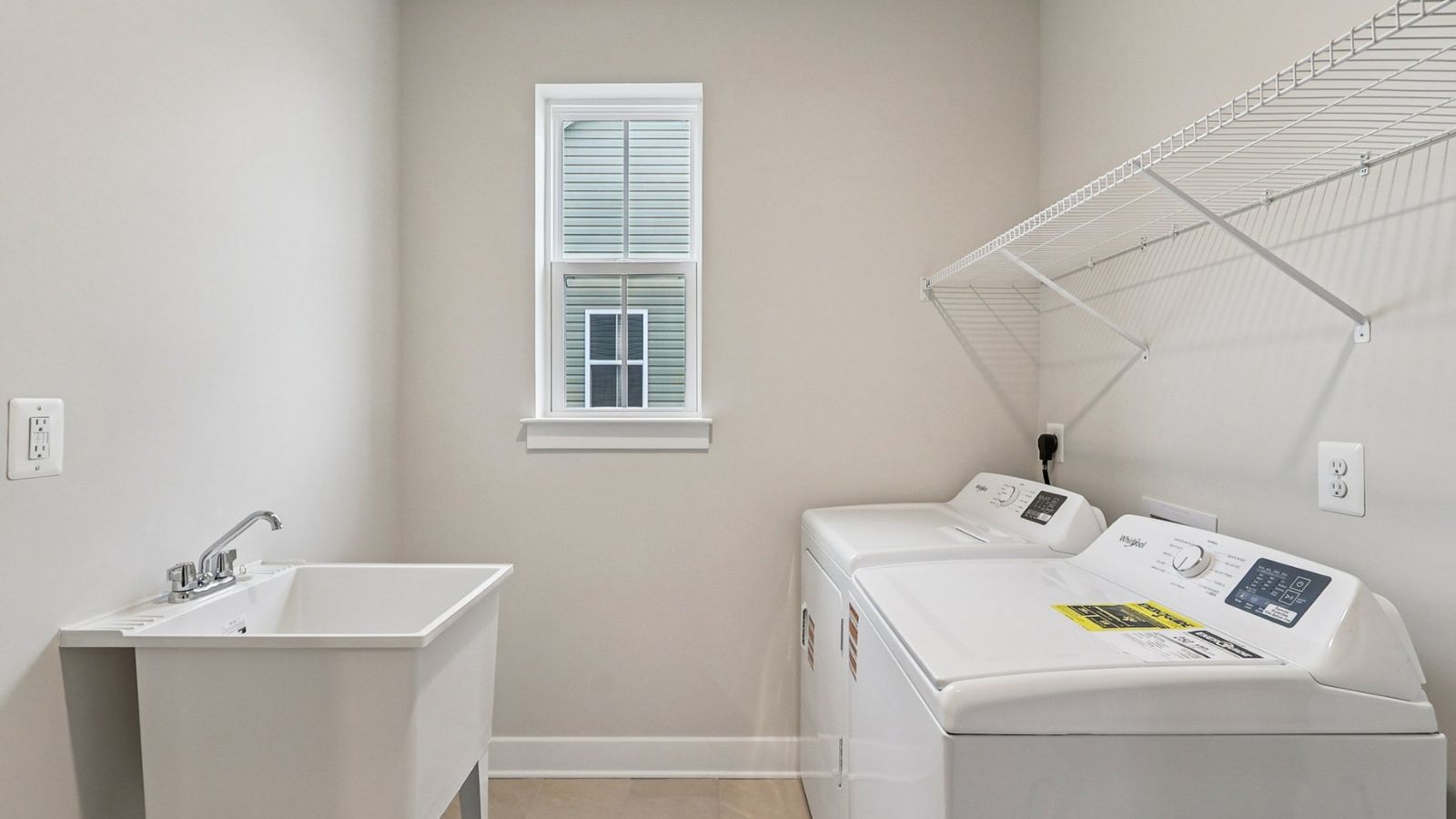 Convenient laundry room in a new Fredericksburg VA single-family home featuring functional workspace and storage options.