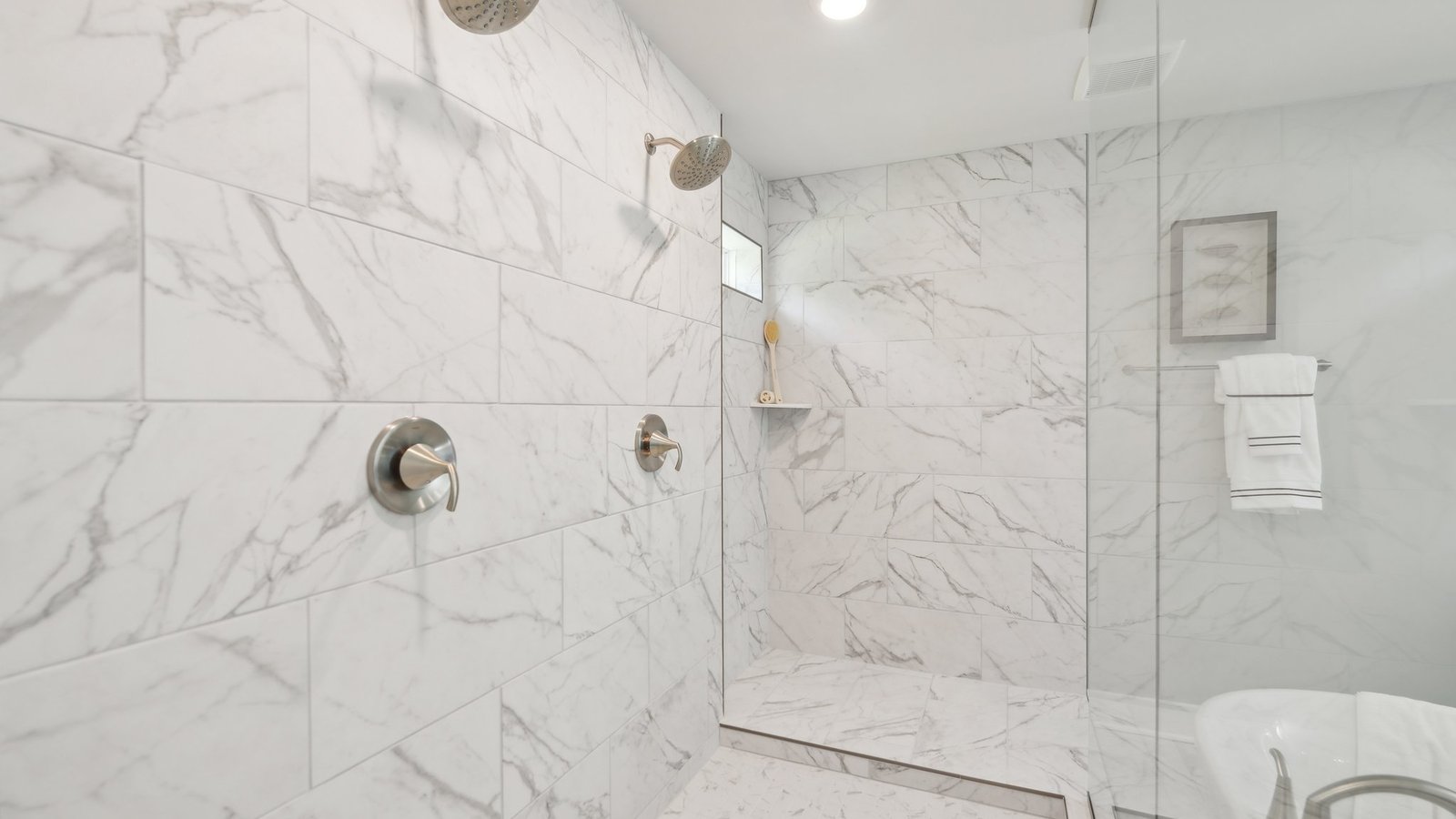 primary full bathroom with separate vanities walk in shower and soaking tub