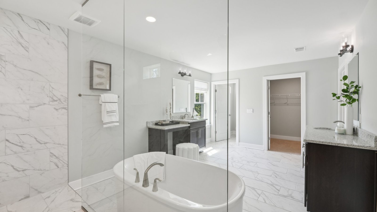 full primary bathroom with two separate vanities and walk in shower and soaking tub