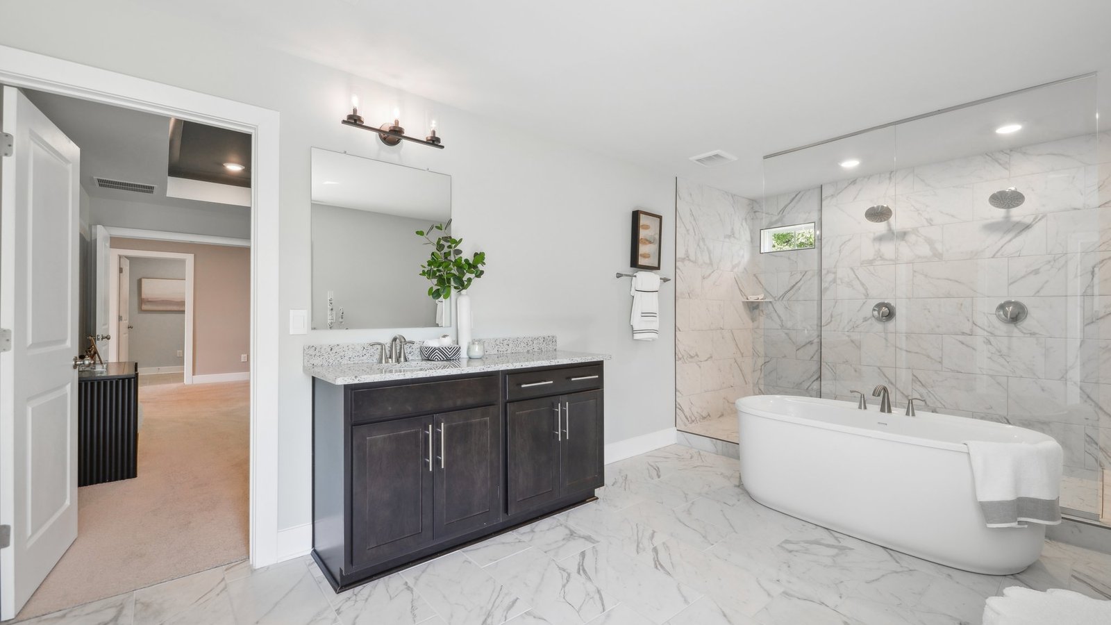 full primary bathroom with two separate vanities and walk in shower and soaking tub