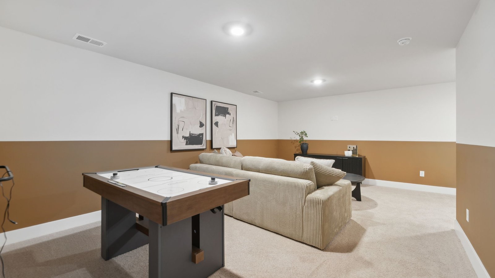 living room and game area in basement