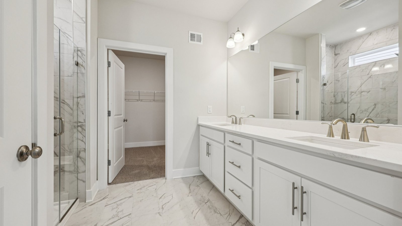 Beautiful dual vanity in the primary bathroom as well as a large mirror