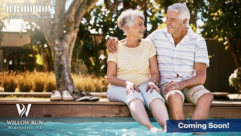 an elderly couple sitting on the edge of a pool