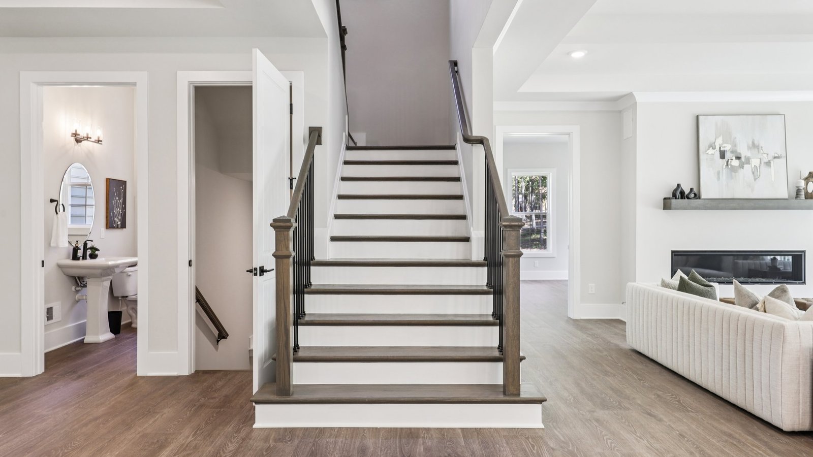 powder room is located to the left of the staircase