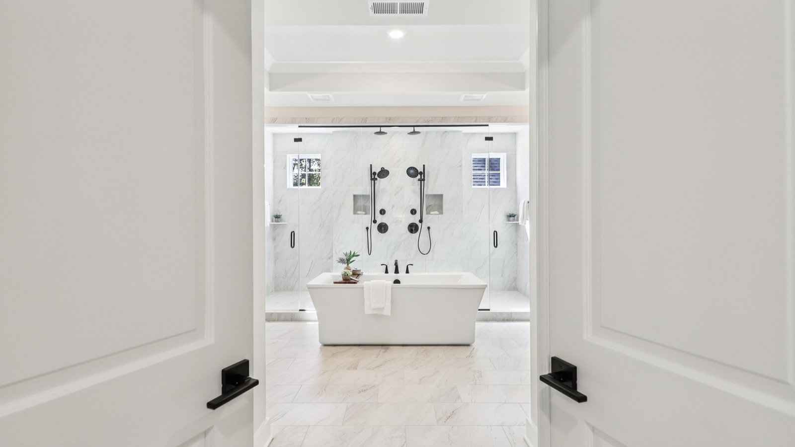 double doors open to a luxurious primary bath