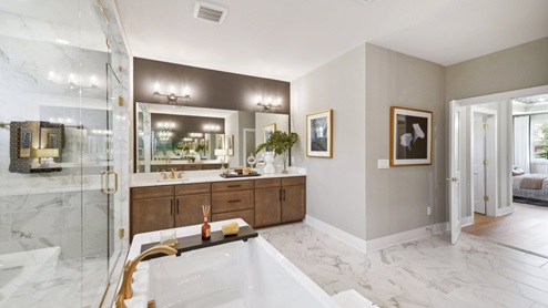 Right outside the glass shower doors is a large bathtub