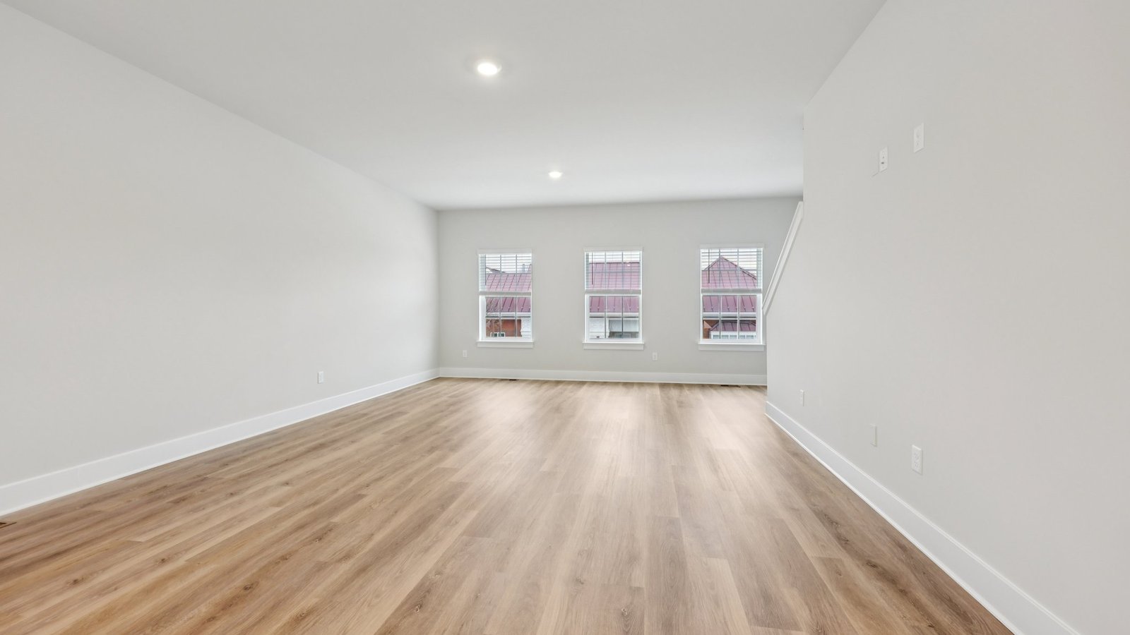 Living room — bright space with wall of windows, orchid artwork, and modern seating.
