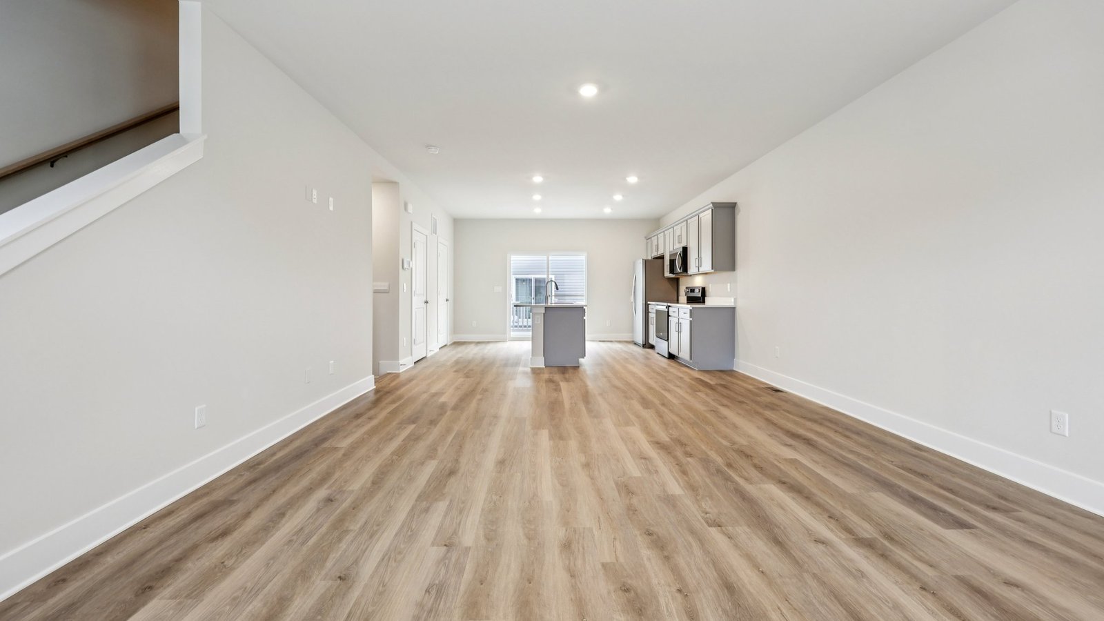 Open concept — living, dining, and kitchen in a light-filled space with large windows.