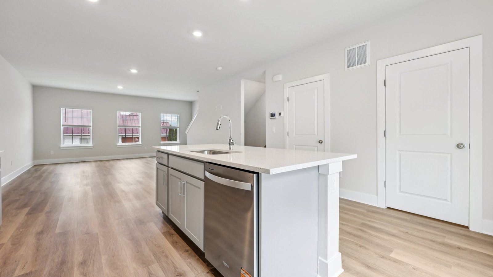 Kitchen and great room — long island facing living area with large sunny windows.