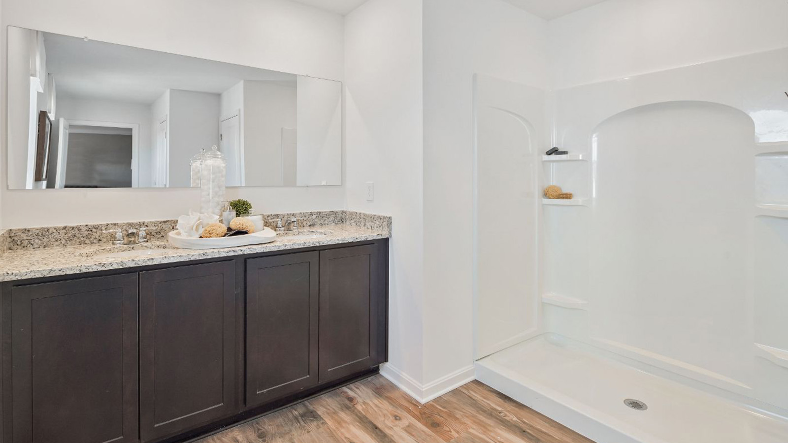 primary bathroom with dual sink vanity and walk in shower