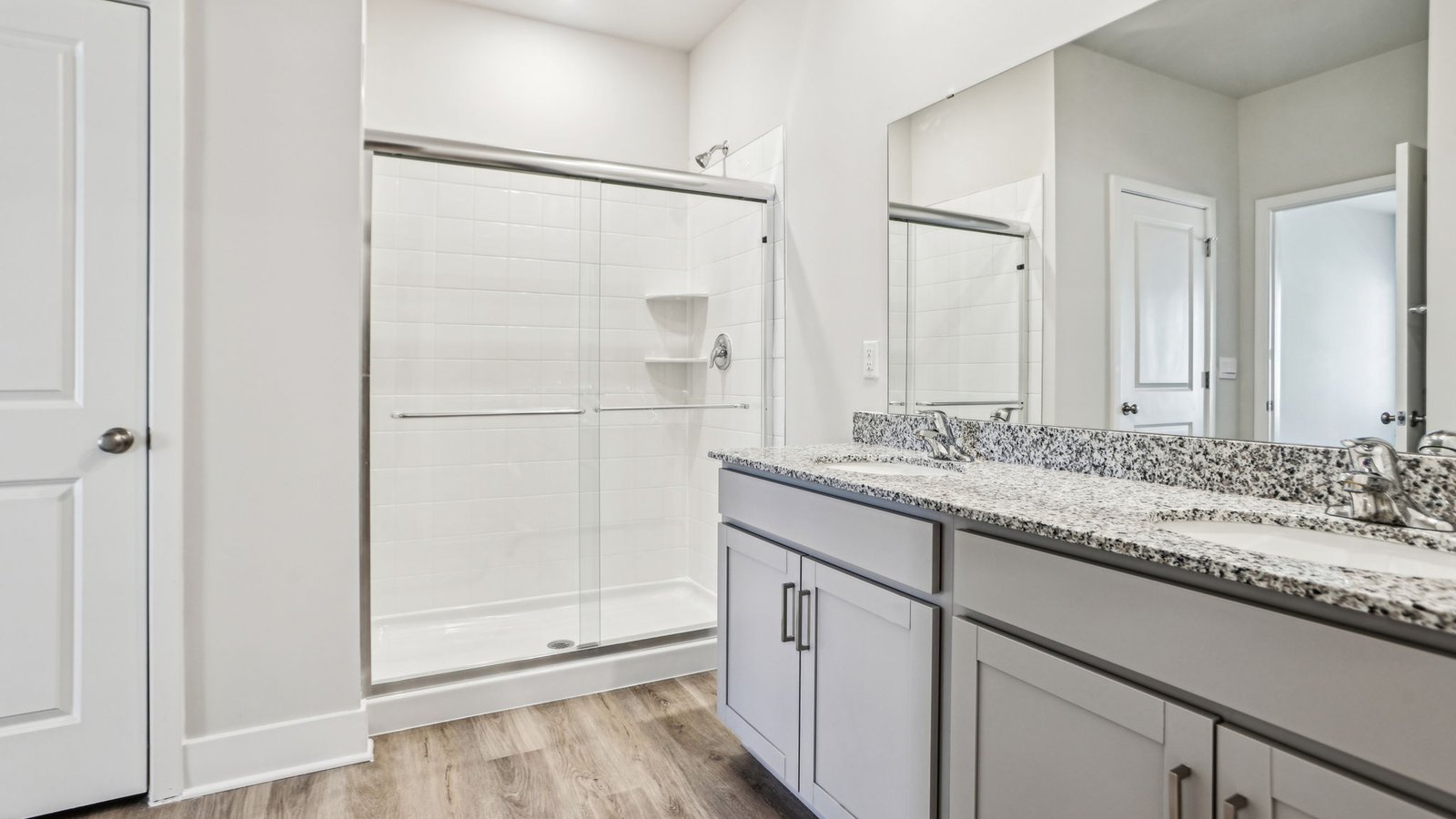 primary bathroom with dual sink vanity and walk in shower