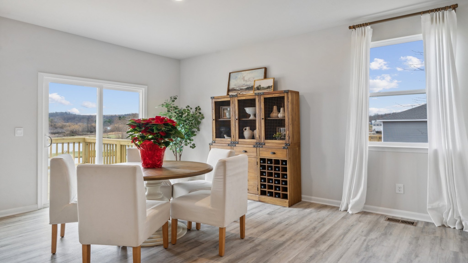 Smartly designed dining room in D.R. Horton Spring Lakes near main outdoor access, kitchen, living room