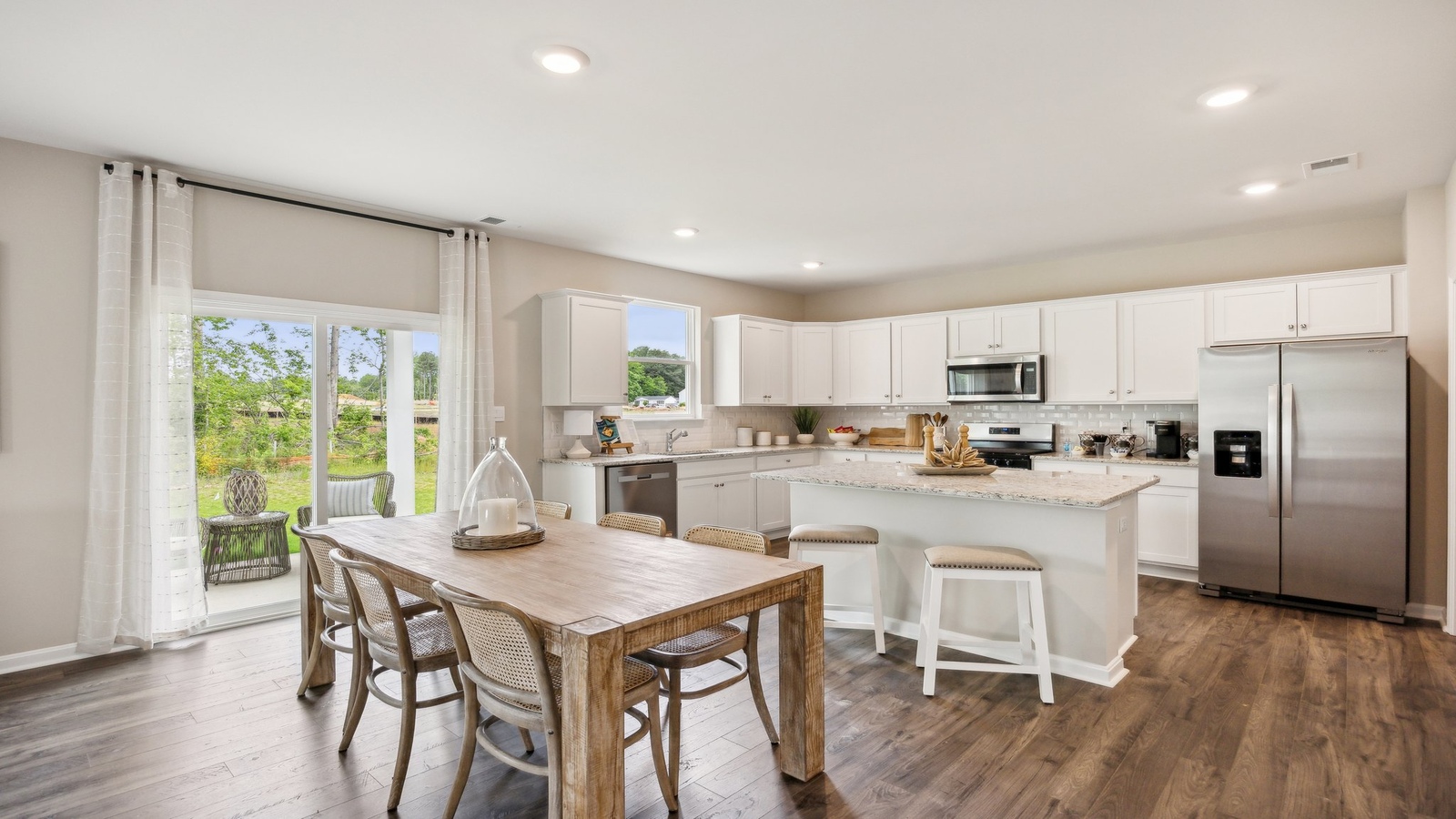 New appliances and larger kitchen island with seating anchor the kitchen, next to dining, great rooms, pantry, outside access