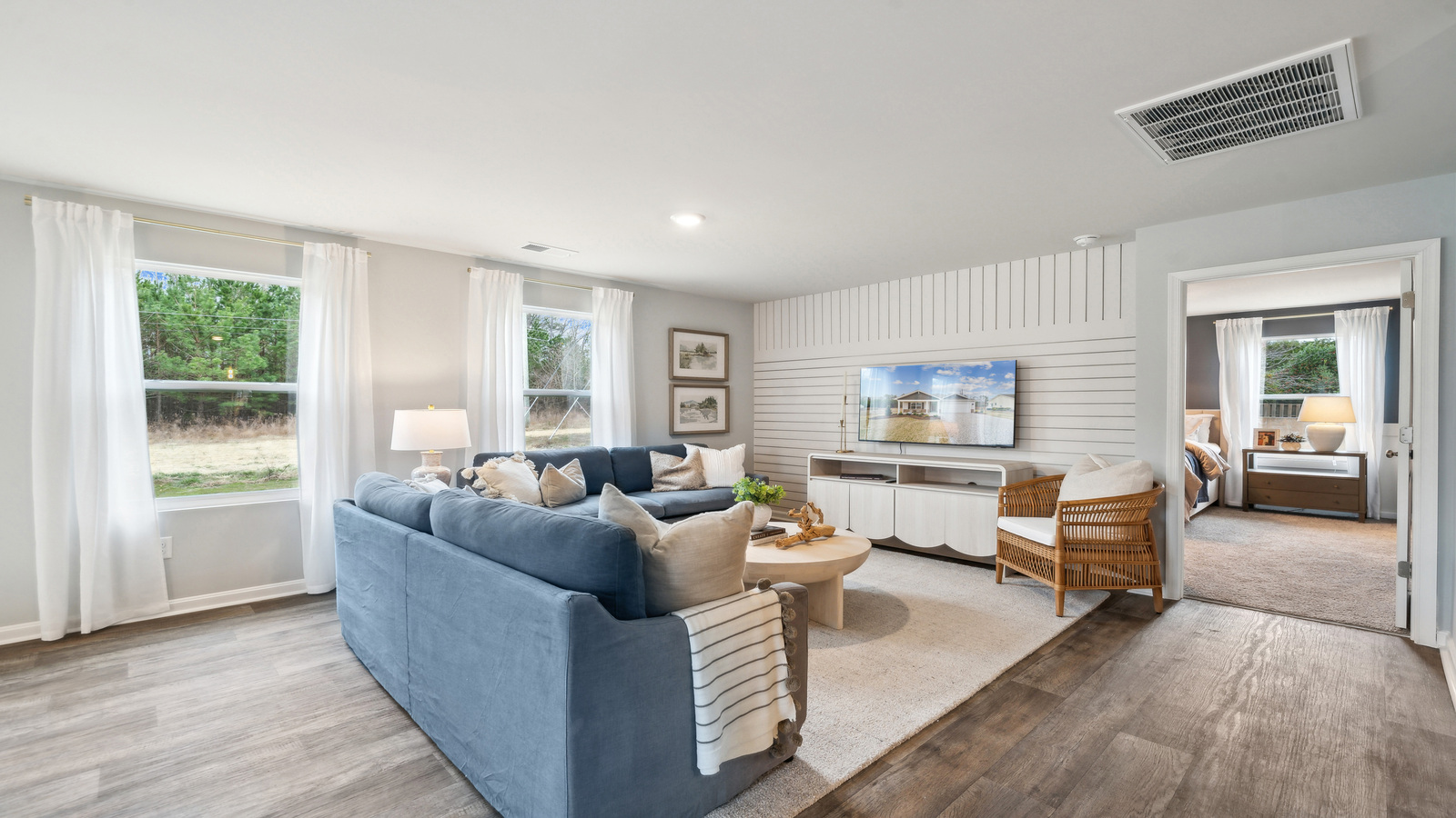Living room in this new construction home features natural light, with fresh open concept flow to the kitchen, dining areas