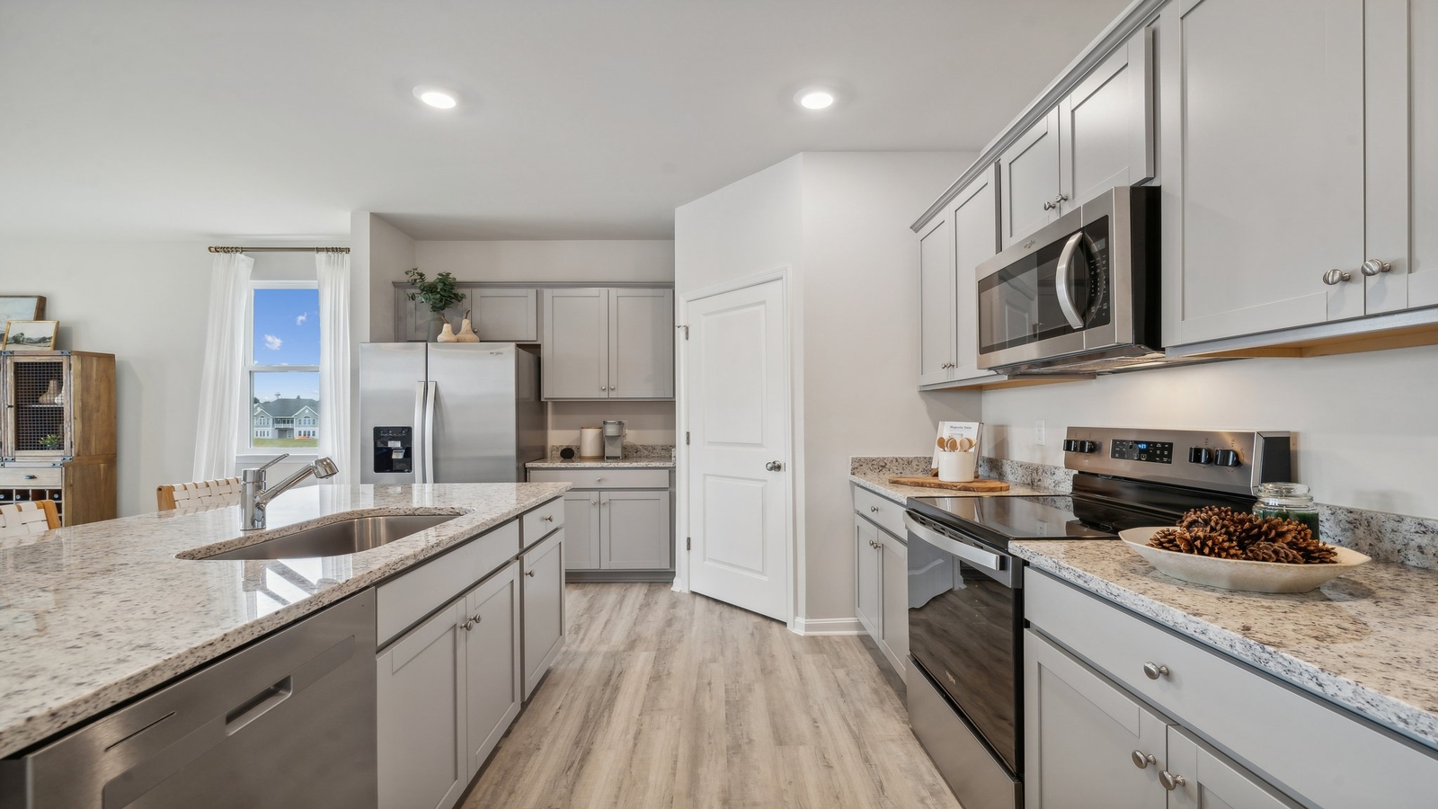 New appliances and larger kitchen island with seating anchor the kitchen, next to dining, great rooms, pantry outside access