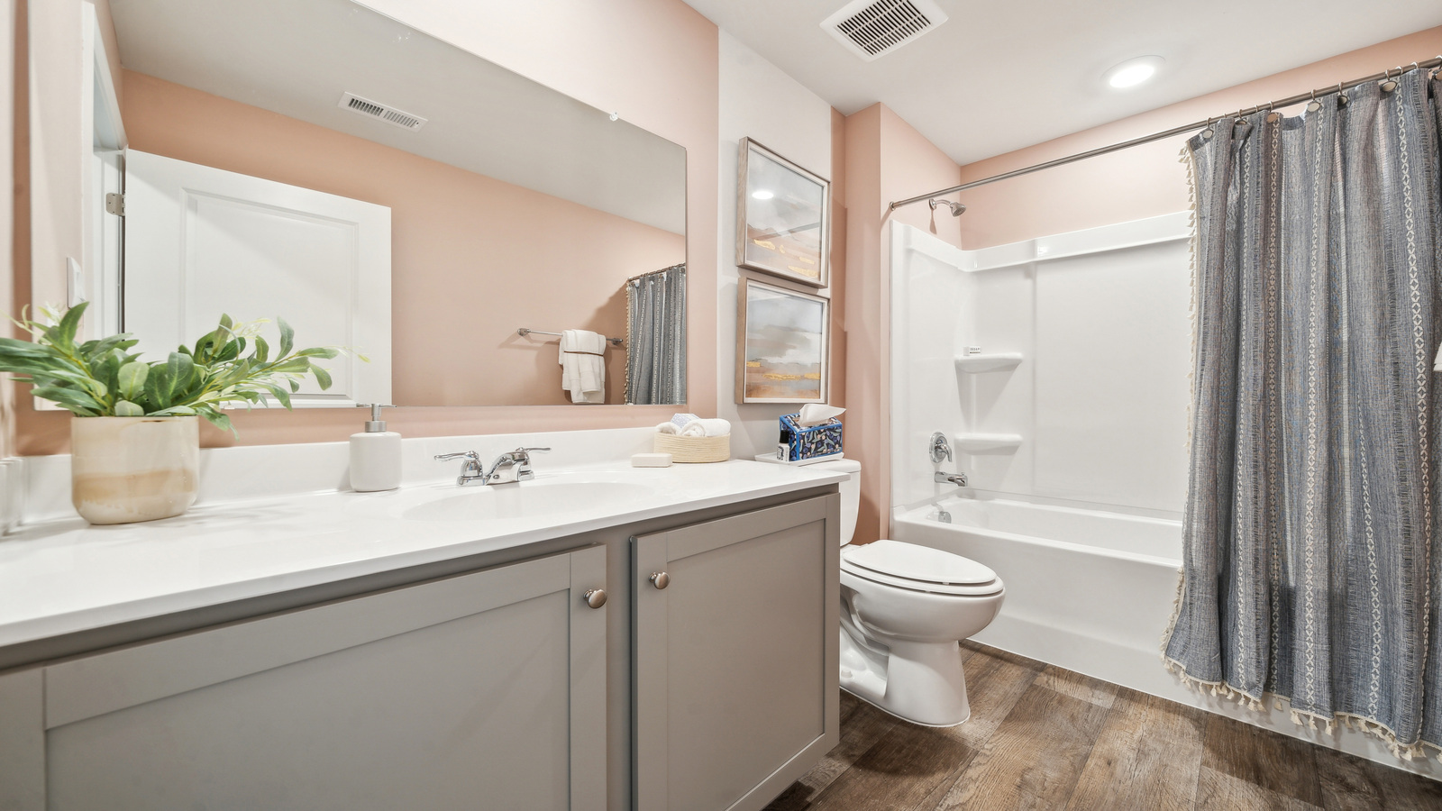 Secondary bathroom adds stylish combination shower-tub, cabinets, vanity, and mirror at Eagle Ridge