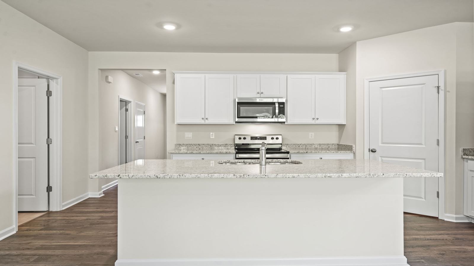 Spacious kitchen in this new construction house featuring a bright layout, sink, pantry, upgraded island, new appliance suite