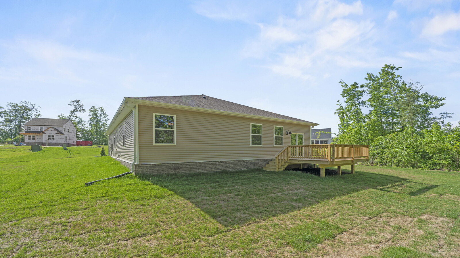 New build home with sturdy back deck by D.R. Horton featuring grass lawn, large backyard