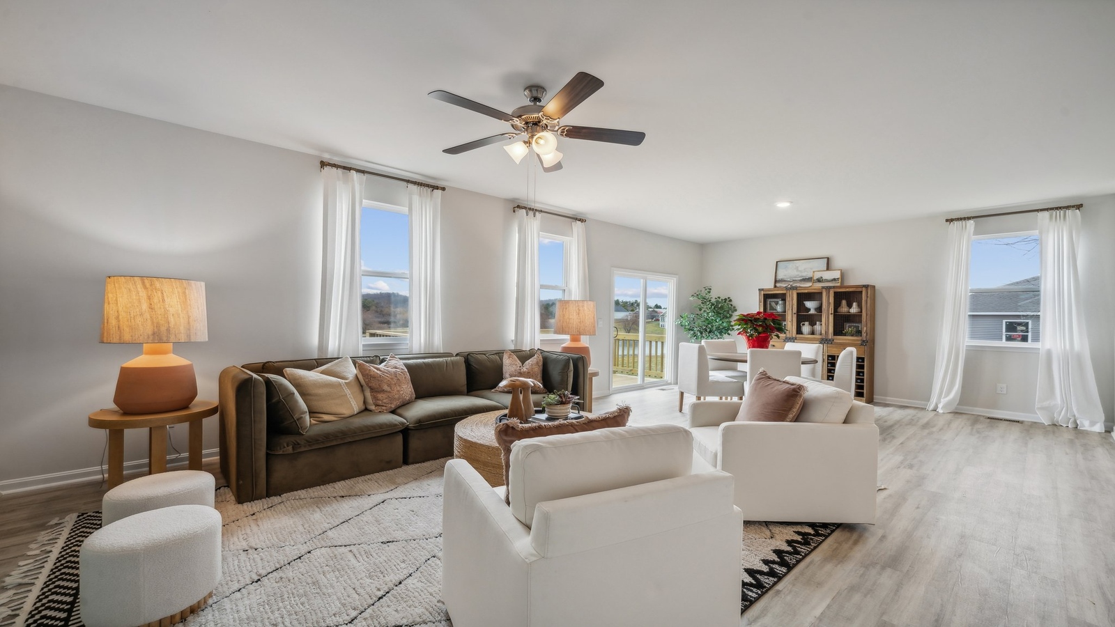 Living room in this new construction home features natural light, with fresh open concept flow to the kitchen, dining areas