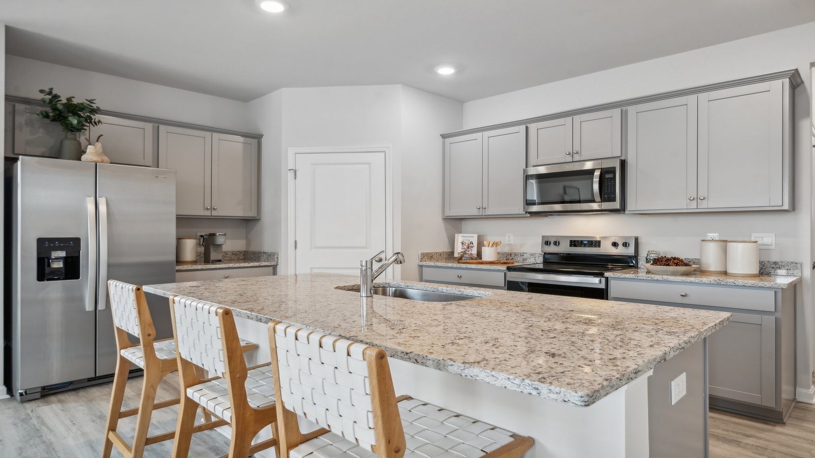 New home kitchen island with seating, pantry, ample cabinet storage, new appliance suite, and multi-prep zones