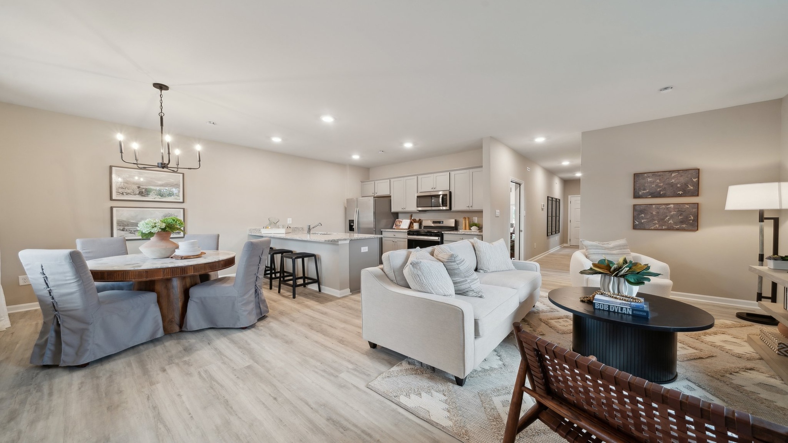 Spacious living room looking toward modern kitchen with island, dining, new appliances at Watermark