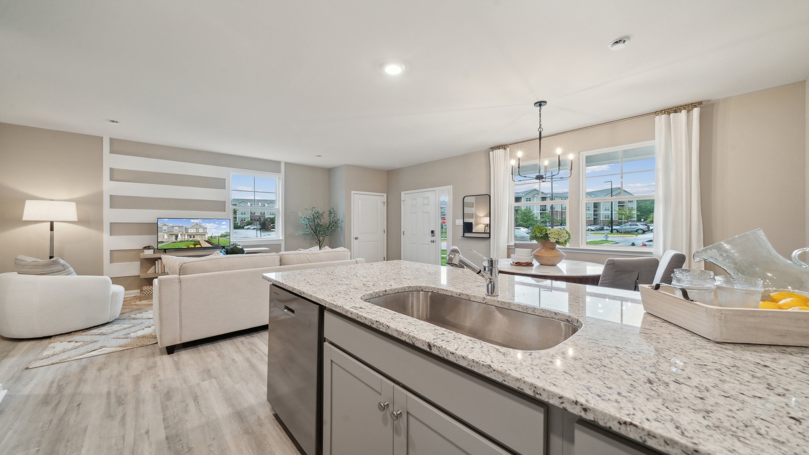 Kitchen-dining-family room blend together with access to dining nook-living areas, and backyard views in new home