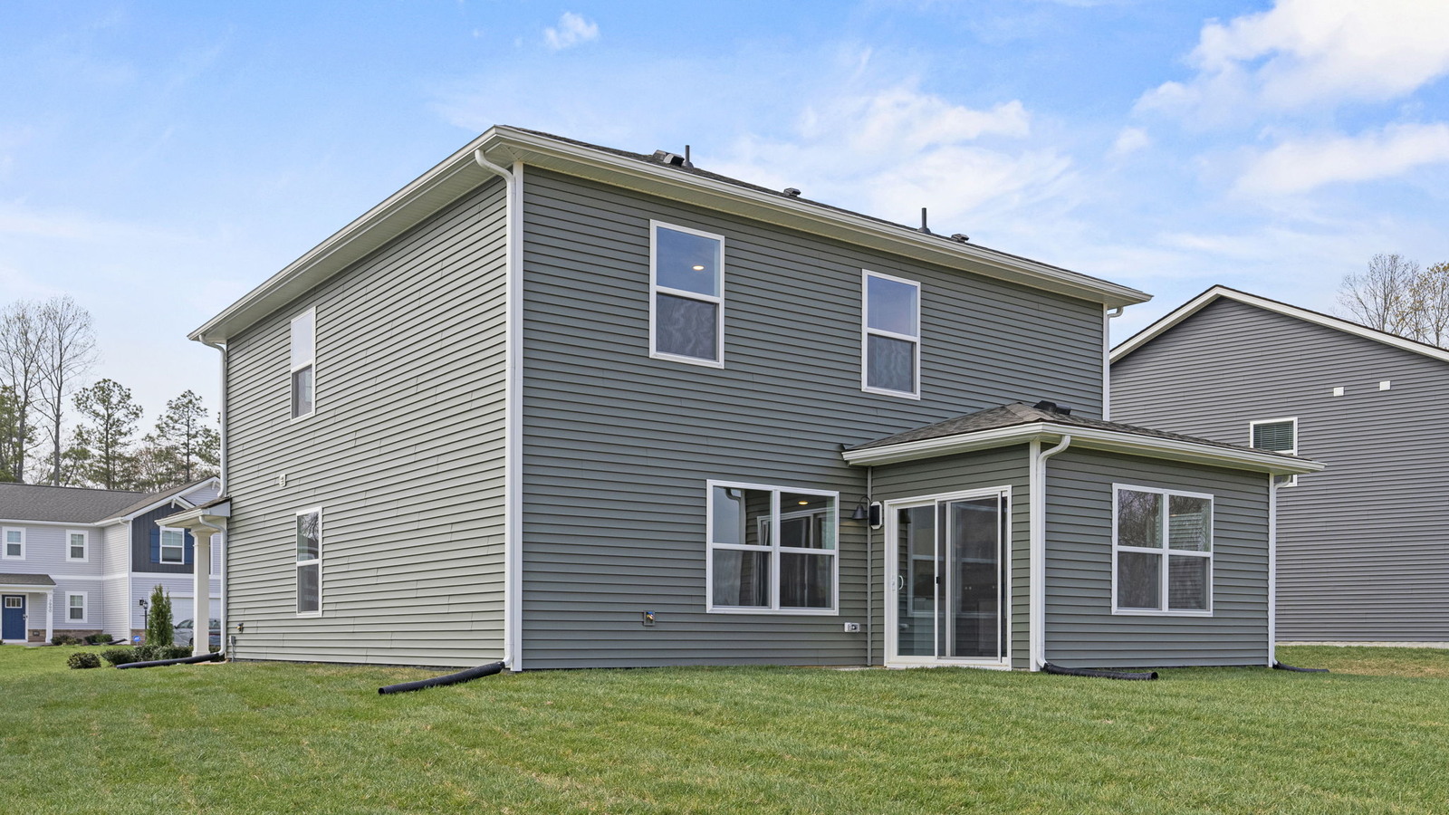 Backyard in this New Home with full lawn, covered patio slab, and fencing potential for added privacy options