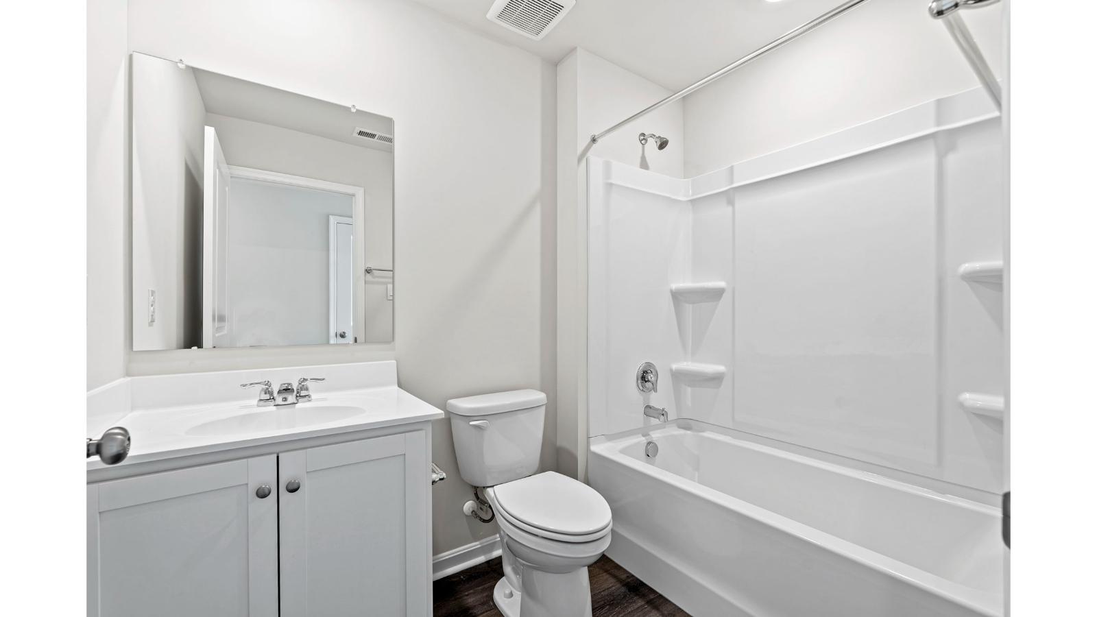 Secondary bedroom with clean design, single window, and walk-in closet access in Arbors at Farms of New Kent