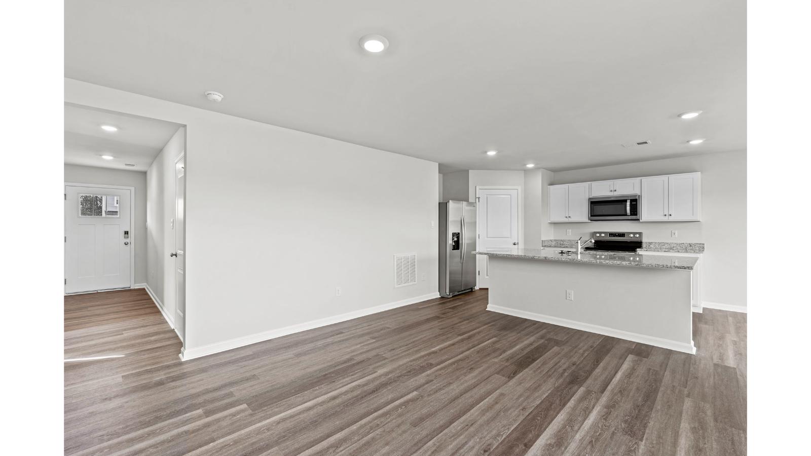 Functional island kitchen with seating, durable countertops, modern LED lighting, and connected dining-living areas