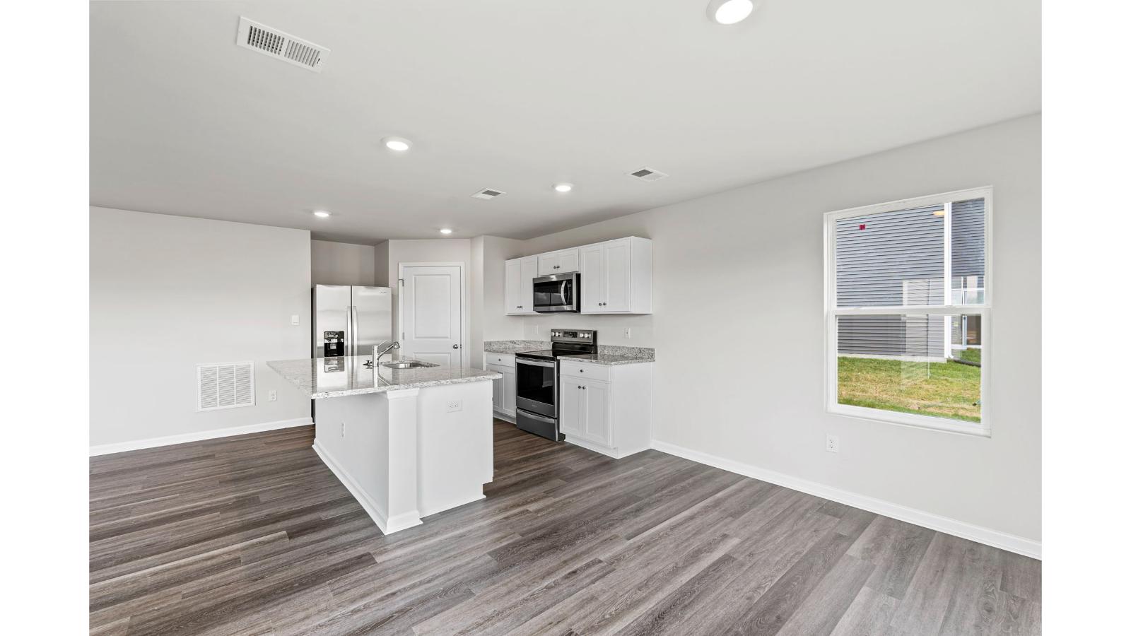 Kitchen in this New Home features a large island with seating, New appliances, and Modern Design finishes.