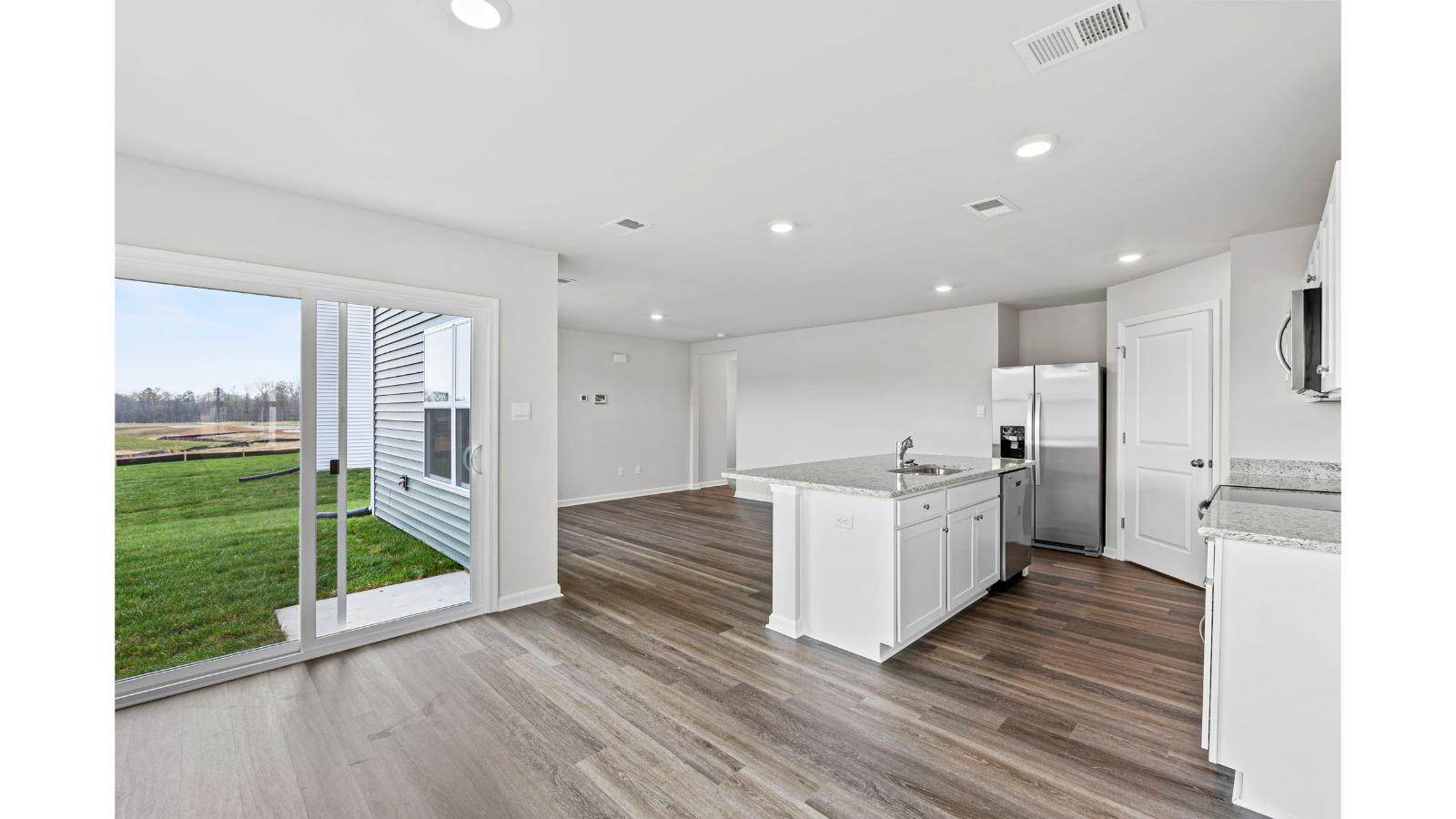 Kitchen and family room blend together with quality flooring, access to dining nook-living areas, backyard views in New Home