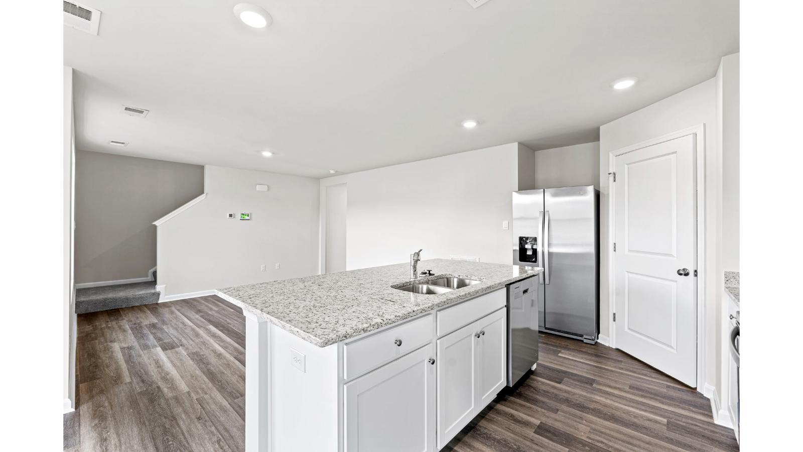 New Build Home kitchen showcasing large center island with LED lighting, durable surfaces, multiple seating options