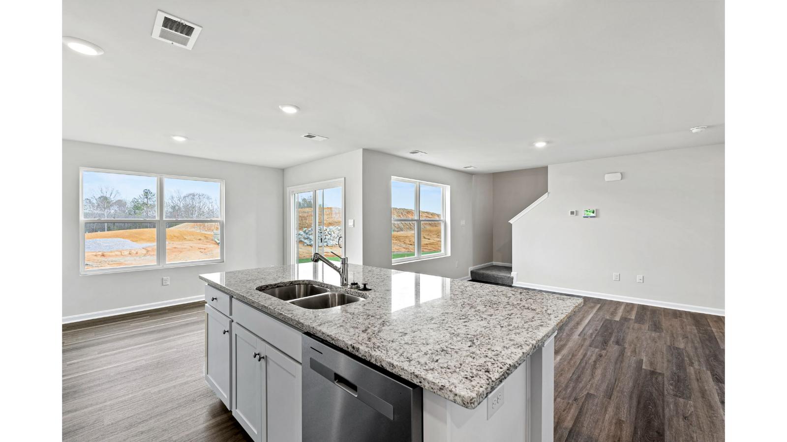 Integrated living and kitchen areas in Arbors at Farms of New Kent home offers Modern Design layout, use of space, rear yard visibility.