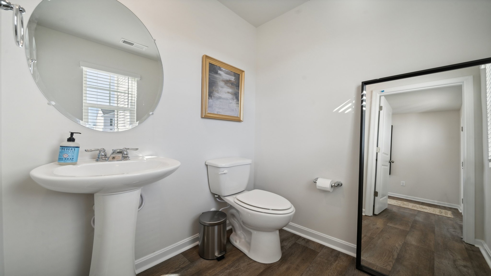 Half bath with door open to hallway, pedestal sink visible with silver faucet in Arbors at Farms of New Kent