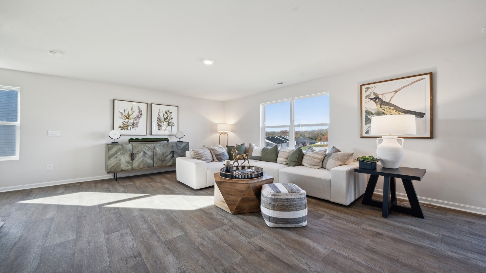 Living room designed by D.R. Horton showcases central access to the rear patio, kitchen and bedrooms