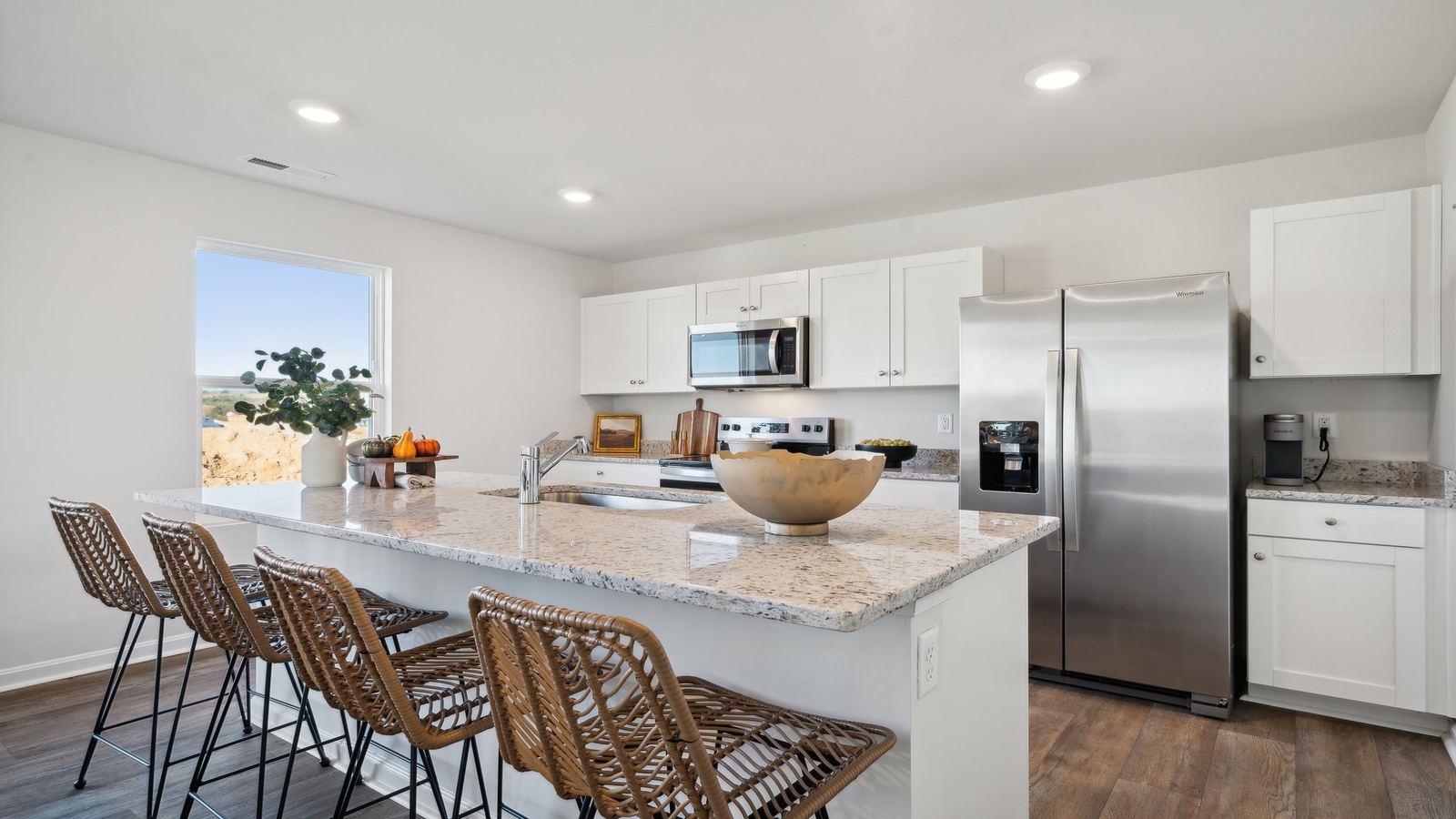 Functional kitchen design with corner pantry, island, and staircase view in Arbors at Farms of New Kent