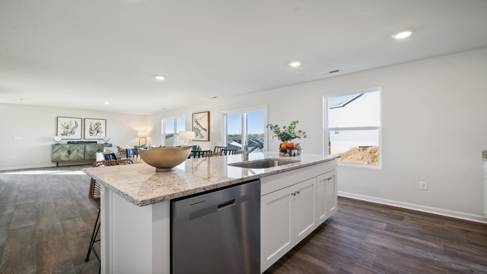 Arbors at Farms of New Kent kitchen with hard surface island and adjacent stairwell under recessed lighting