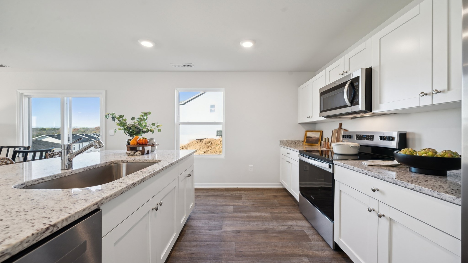 Kitchen-Dining and living room combination with hard surface countertops and stairway access in Arbors at Farms of New Kent