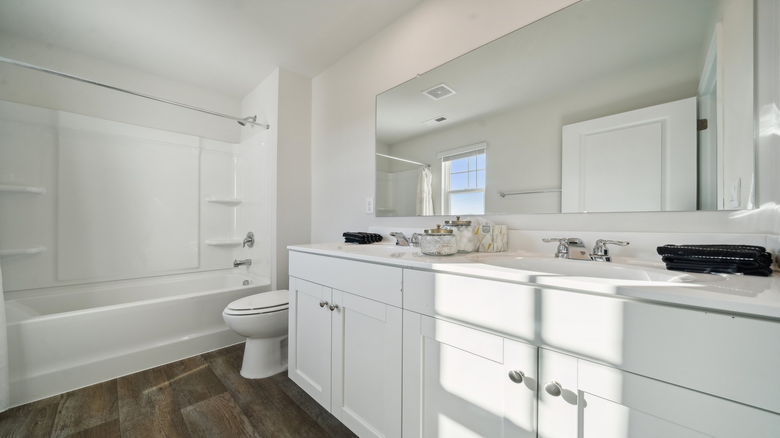 Modern family bath with vanity lighting, storage, quality fixtures in Arbors at Farms of New Kent by D.R. Horton
