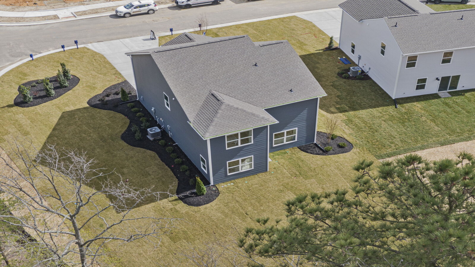 Drone view of residential Arbors at Farms of New Kent showing D.R. Horton homes, backyards, driveways and landscaped yards