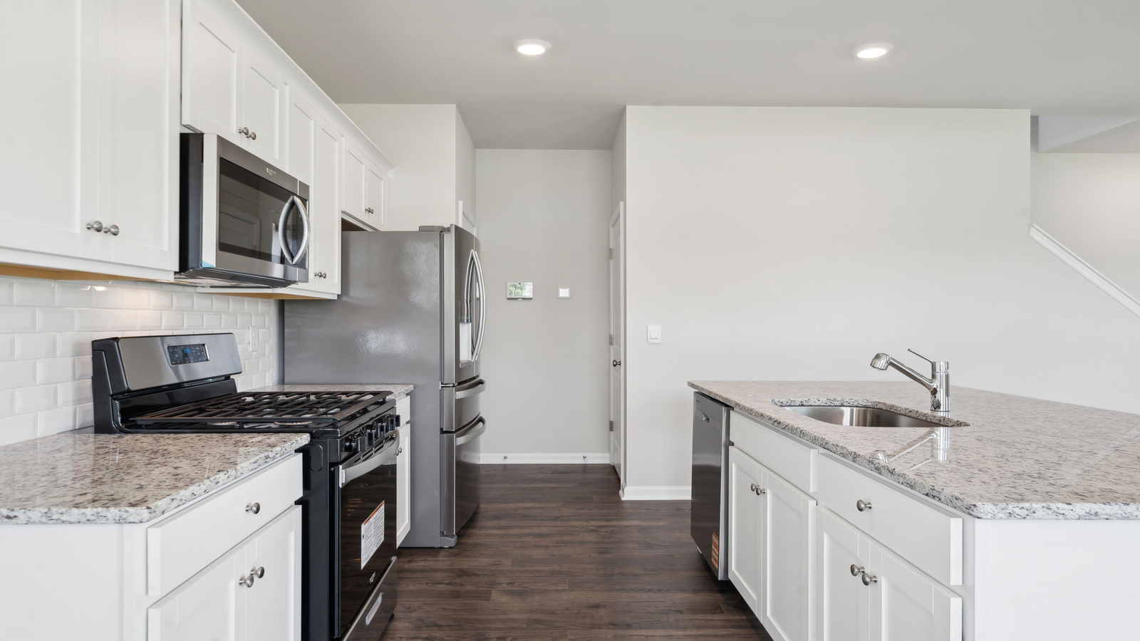 Spacious kitchen with island, pantry, dining and family area, and brand-new appliances throughout in Arbors at Farms of New Kent